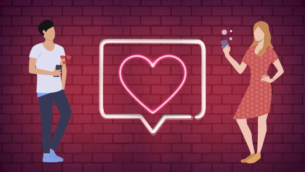 A man and a woman are standing in front of a brick wall. There is a neon pink heart-shaped sign between them.