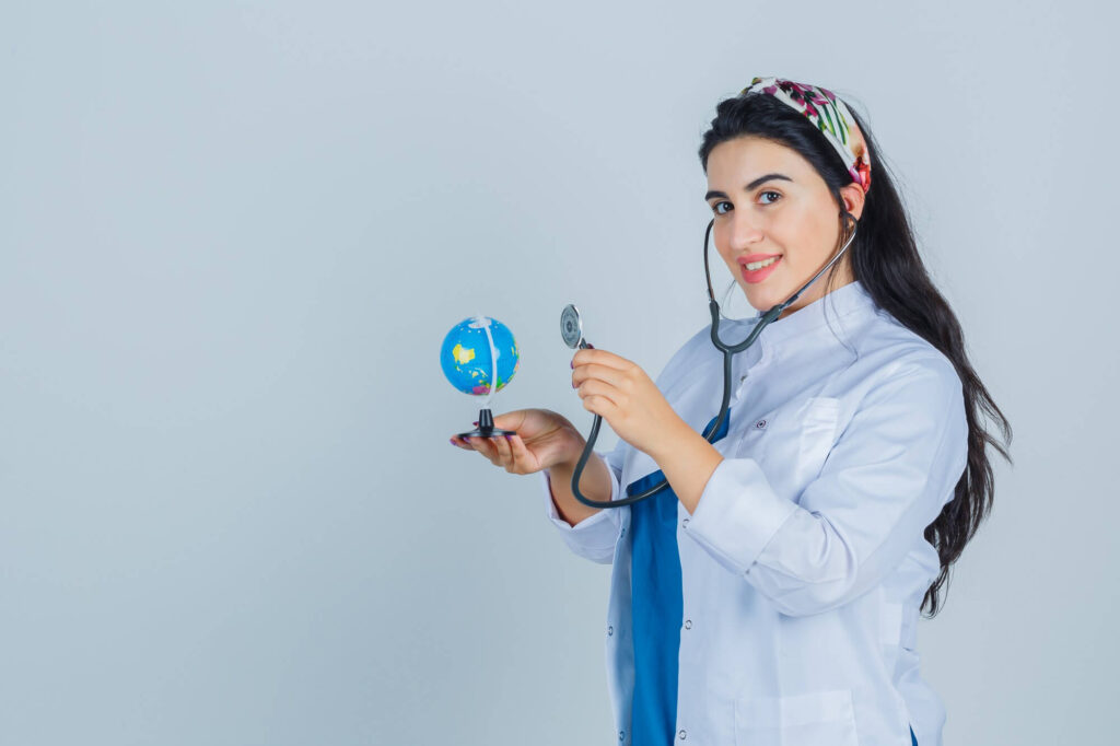 A female doctor in a white coat holding a globe stethoscope