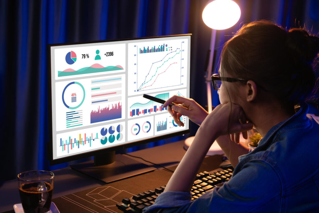 A woman analyzing graphs on a computer screen. - Webco Marketing Blogs