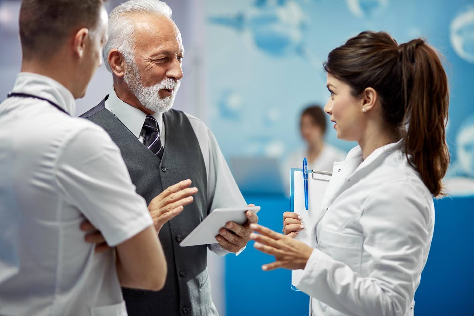 Doctor discussing treatment plan with professionals in hospital room.