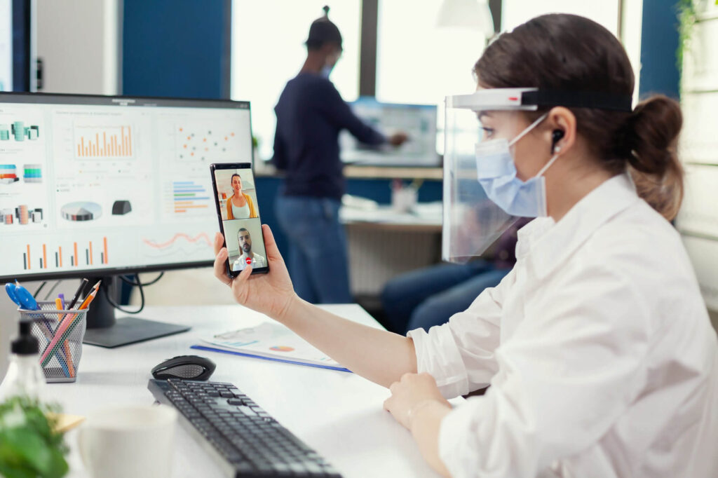 A Female Doctor with mask and glasses on phone.