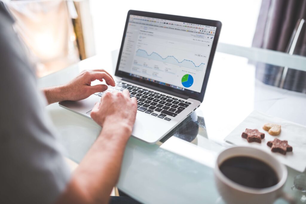 A person focused on a laptop displaying a graph, analyzing data for insights and decision-making - Webco Marketing Medical Blogs