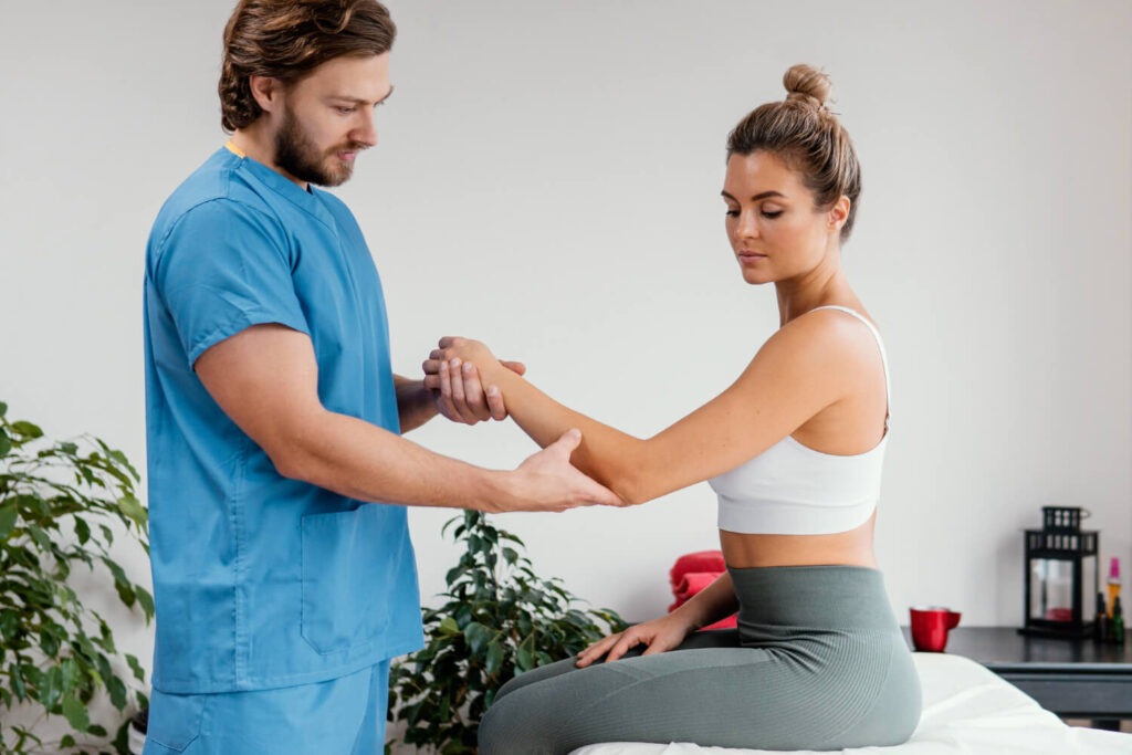 A physiotherapists and woman engage in physical therapy exercises together